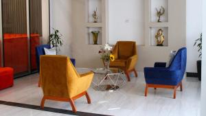 a lobby with three chairs and a glass table at SM HOTEL Plus in Lima