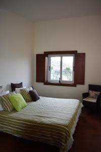 um quarto com uma cama grande e uma janela em O Cantinho Alentejano em Cuba