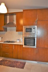 a kitchen with wooden cabinets and a microwave at O Cantinho Alentejano in Cuba