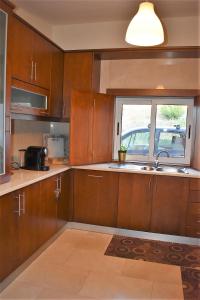 a kitchen with wooden cabinets and a sink and a window at O Cantinho Alentejano in Cuba