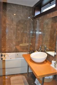 ein Badezimmer mit einem Waschbecken und einer Theke mit einem Spiegel in der Unterkunft O Cantinho Alentejano in Cuba