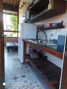 a kitchen with a sink and a refrigerator at Vila Artesania in Bombinhas