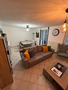 uma sala de estar com um sofá e uma mesa em Appartement de Camargaux 70m2 secteur très calme em La Bresse