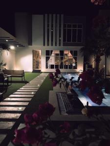 un edificio con piscina con fiori al centro di شاليه بالم ون الفندقي a Buraydah
