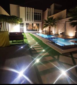 a swimming pool with lights on the floor of a building at شاليه بالم ون الفندقي in Buraydah