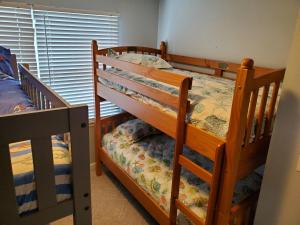 two bunk beds in a room with a window at Family Friendly Beach Block Ocean View 3 BR, 2 BA, Condo near Wildwood Crest and Convention Center in Wildwood