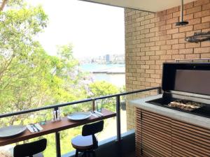 a balcony with a grill and a table and chairs at Manly family executive apartment in Sydney