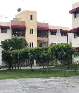 un bâtiment avec des arbres devant lui dans l'établissement Precioso apartamento, residencial ideal familia, à Saint-Domingue