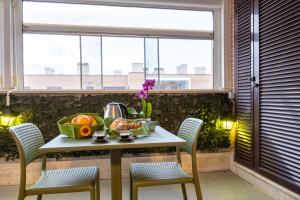 uma mesa com uma taça de fruta numa varanda com uma janela em The Top Floor - Rome FCO Airport em Fiumicino