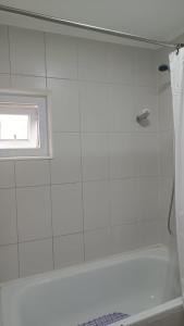 a white bathroom with a tub and a window at Casa Don Alonso Temuco in Temuco