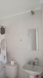 a white bathroom with a toilet and a sink at Casa Don Alonso Temuco in Temuco