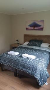 1 dormitorio con 1 cama con 2 toallas en Casa Don Alonso Temuco, en Temuco