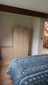 a bedroom with a bed and a wooden cabinet at Casa Don Alonso Temuco in Temuco