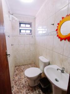 a bathroom with a toilet and a sink at Diva Surf Quartos in Ubatuba