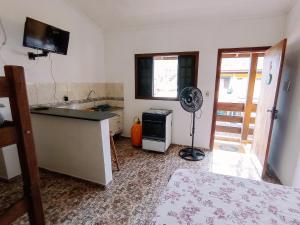 a kitchen with a sink and a fan in a room at Diva Surf Quartos in Ubatuba +26 photos