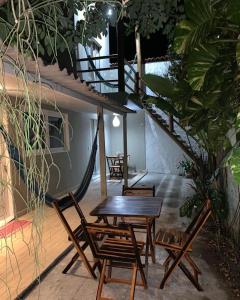 a patio with a hammock and tables and chairs at Recanto do Mar in Pipa