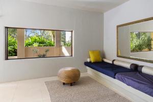 a bedroom with a blue bench and a mirror at Golden Streams in Conjola