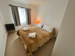 a bedroom with a bed with towels on it at Bahía Golondrina in Ushuaia