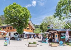 un marché avec un arbre devant un bâtiment dans l'établissement Gite LE SEMNOZ, à Montmin