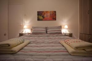 a bedroom with a large bed with towels on it at Lovely Nest Piraeus in Piraeus