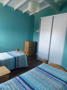 ein Schlafzimmer mit 2 Betten und einer blauen Wand in der Unterkunft Casa Mar Chiquita in Balneario Mar Chiquita