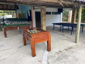 two ping pong tables in a room with a pool table at Excelente Acomodação no Paraíso das Águas, Studio no Resort ILOA em Alagoas in Barra de São Miguel