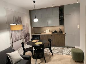 a living room with a table and a kitchen at Apartamenty Sonata, Mazury, Szczytno in Szczytno