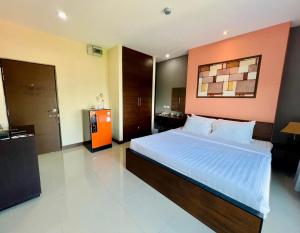 1 dormitorio con 1 cama grande y pared de color naranja en Ma Chic & Cozy en Lampang