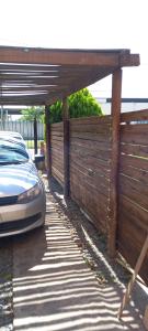 una valla de madera con un coche aparcado debajo en el descanso en San Antonio de Areco