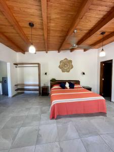 a bedroom with a large bed with a wooden ceiling at Solez Zihuatanejo in Zihuatanejo