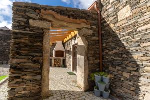 una entrada a un edificio de piedra con una pared de piedra en Casa da Avó Ana, 