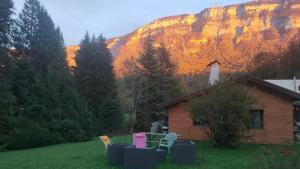 a house with chairs in front of a mountain at La tanière du lac d Aiguebelette in Lepin-le-Lac