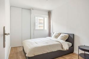 - une chambre avec un lit, une table et une fenêtre dans l'établissement Appart spacieux près de la Seine, à Sartrouville