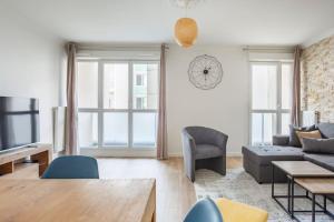 - un salon avec un canapé et une table dans l'établissement Appart spacieux près de la Seine, à Sartrouville