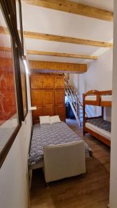 a bedroom with a bed and two bunk beds at La Casa Degli Artisti - presso Sussy Residence in Falcade