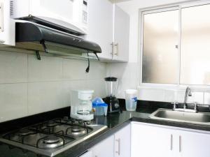 a kitchen with a stove and a sink at Apto completo Atures la mejor vista y ubicación! in Pasto