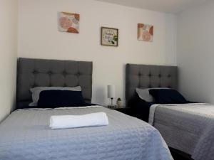 1 dormitorio con 2 camas y almohada blanca en Apto completo Atures la mejor vista y ubicación!, en Pasto