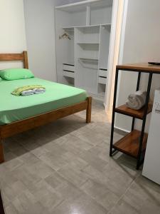 a bedroom with a bed and a tiled floor at Quarto com entrada independente in Paraty