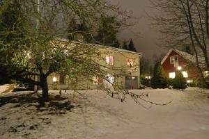 a house with lights on in the snow at night at Göte`s B&B in Tumba