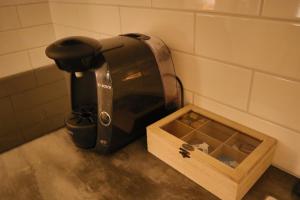 una macchinetta del caffè seduta accanto a un contenitore di legno di Göte`s B&B a Tumba