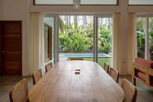 a dining room with a wooden table and chairs at Villa Ikris - tranquil oasis in the heart of Canggu in Canggu