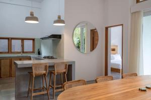 a kitchen and dining room with a table and chairs at Villa Ikris - tranquil oasis in the heart of Canggu in Canggu