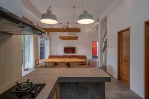 a kitchen with a table and a dining room at Villa Ikris - tranquil oasis in the heart of Canggu in Canggu