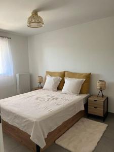 a bedroom with a large bed with white sheets and pillows at Appartement Terrasse vue sur les pistes in Péone