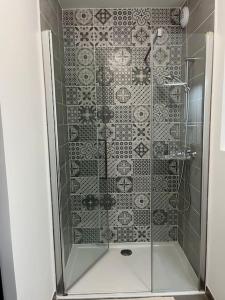 a shower with a glass door and a tile wall at Appartement Terrasse vue sur les pistes in Péone +35 photos