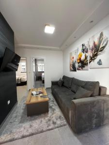 ein Wohnzimmer mit einem Sofa und einem Tisch in der Unterkunft Ortak Apartments in Belgrad