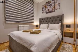 una camera da letto con un grande letto con due asciugamani di Kalman SPA&GYM a Zlatibor