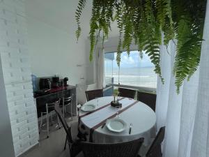 ein Esszimmer mit einem Tisch und einem Fenster in der Unterkunft Itapema-Meia Praia- 3 quartos - Frente Mar! in Itapema