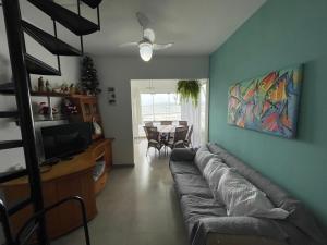 ein Wohnzimmer mit einem Sofa und einem TV in der Unterkunft Itapema-Meia Praia- 3 quartos - Frente Mar! in Itapema
