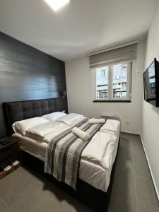 ein Schlafzimmer mit einem großen Bett mit weißer Bettwäsche in der Unterkunft Ortak Apartments in Belgrad